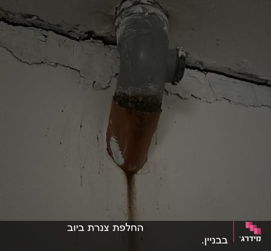 צינור מתכת עם חלודה ודליפה בתקרה